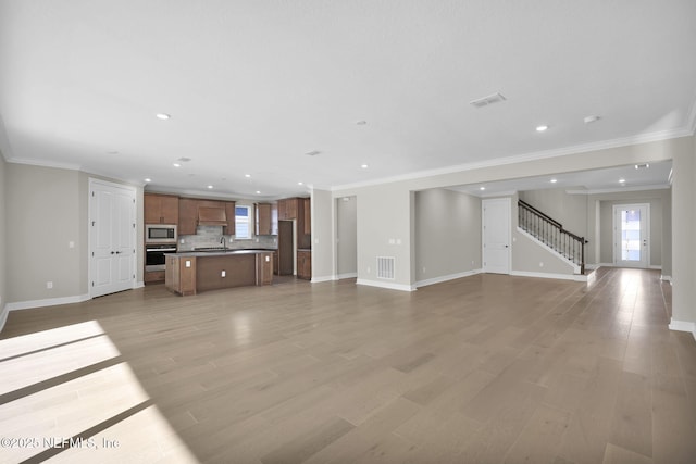 unfurnished living room with light hardwood / wood-style floors and crown molding