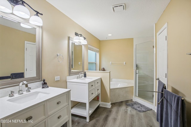 bathroom with vanity, separate shower and tub, hardwood / wood-style floors, and a textured ceiling