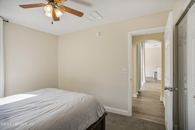 bedroom with a closet, ceiling fan, and dark wood-type flooring