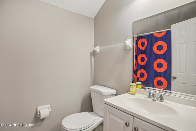 bathroom with vanity, curtained shower, a textured ceiling, and toilet