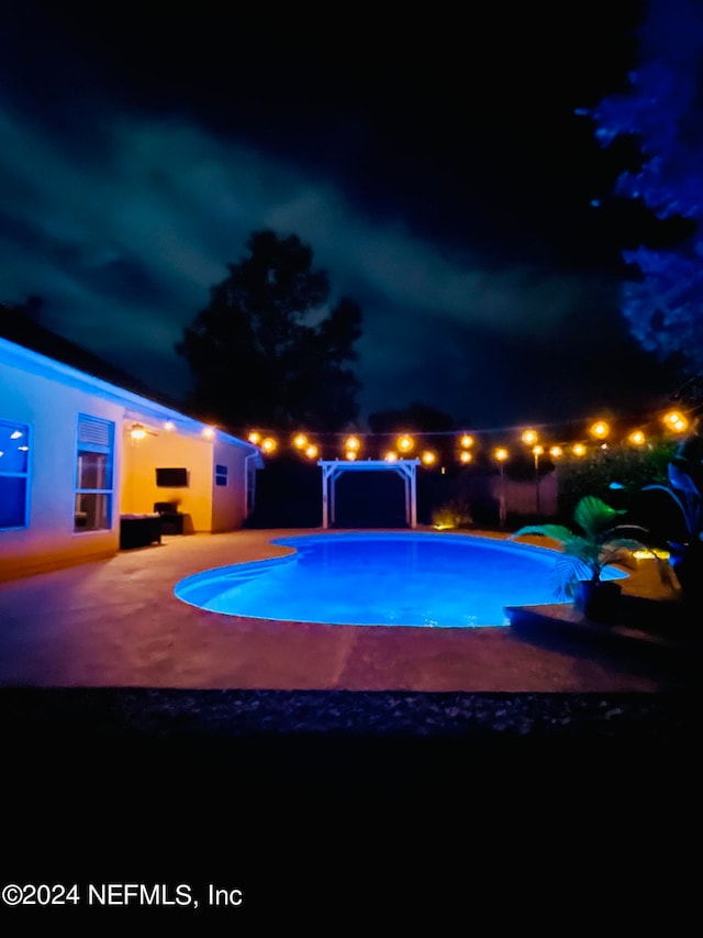 view of pool at twilight