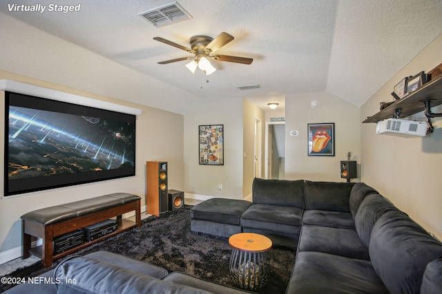 living room featuring lofted ceiling, a textured ceiling, a wall mounted AC, and ceiling fan