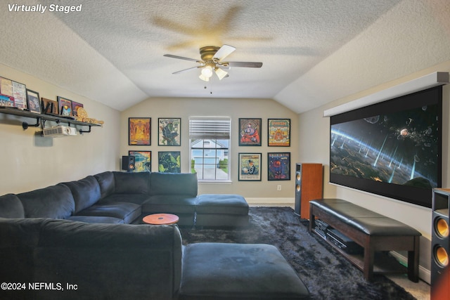 carpeted living room featuring ceiling fan, a textured ceiling, and vaulted ceiling