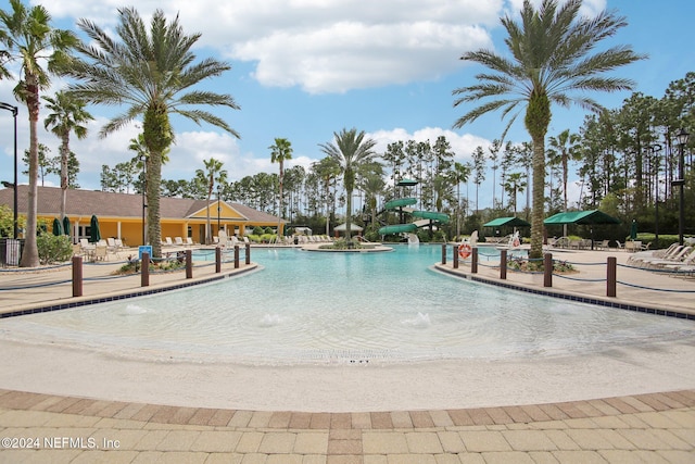 view of swimming pool featuring a water slide, pool water feature, and a patio area