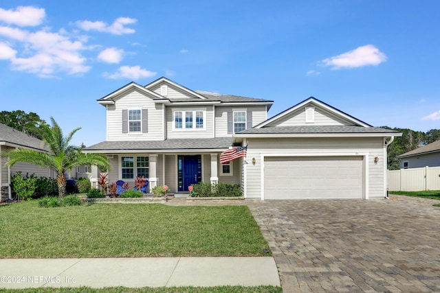 view of front of property featuring a porch, a front lawn, and a garage