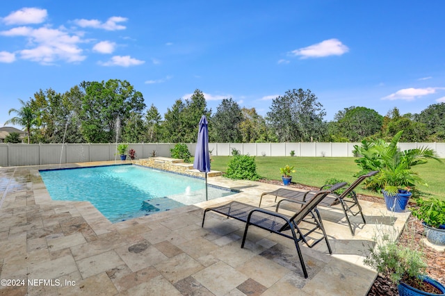 view of pool with a yard, pool water feature, and a patio area