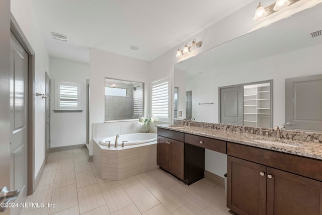 bathroom with vanity, plus walk in shower, tile patterned flooring, and a wealth of natural light