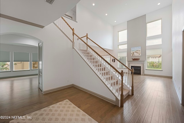 staircase with a high ceiling and hardwood / wood-style flooring