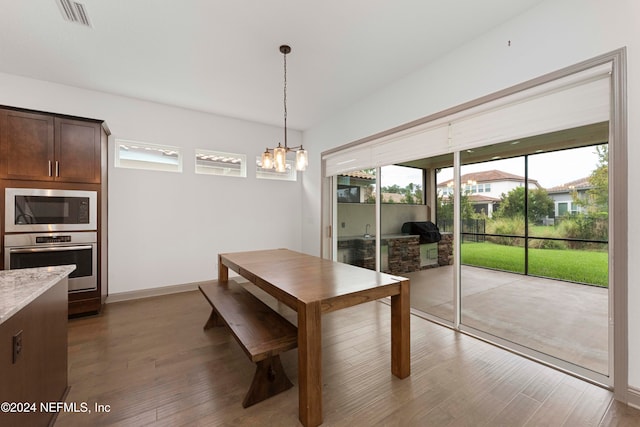 unfurnished dining area with an inviting chandelier and hardwood / wood-style flooring