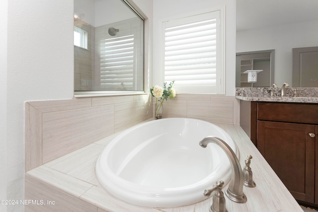 bathroom featuring vanity and shower with separate bathtub