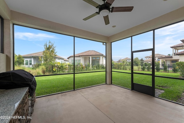 unfurnished sunroom with ceiling fan