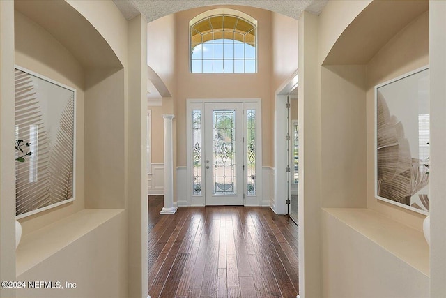 foyer with decorative columns and hardwood / wood-style flooring