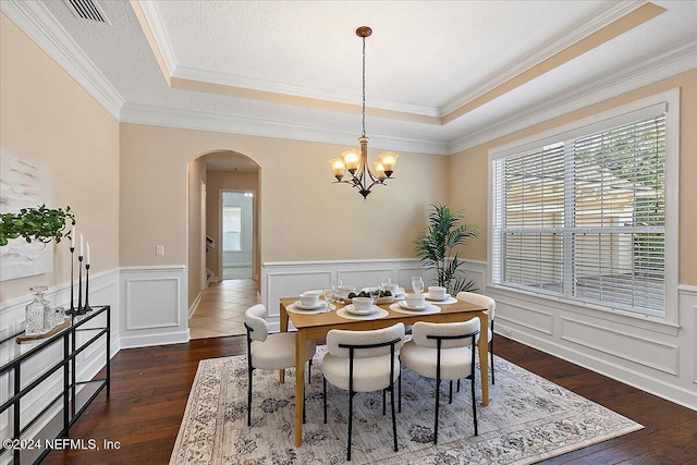 dining area featuring ornamental molding, dark hardwood / wood-style floors, and a tray ceiling