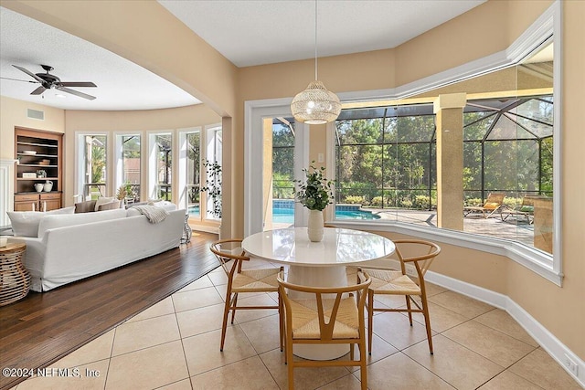 dining area featuring light hardwood / wood-style floors, built in shelves, and ceiling fan