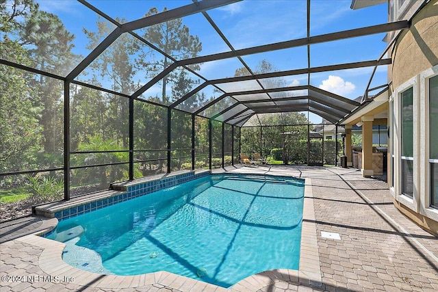 view of swimming pool with a patio and a lanai