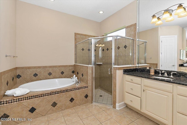 bathroom featuring vanity, a textured ceiling, plus walk in shower, and tile patterned flooring