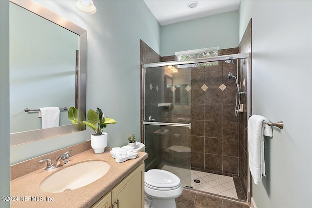 bathroom with vanity, tile patterned floors, toilet, and an enclosed shower