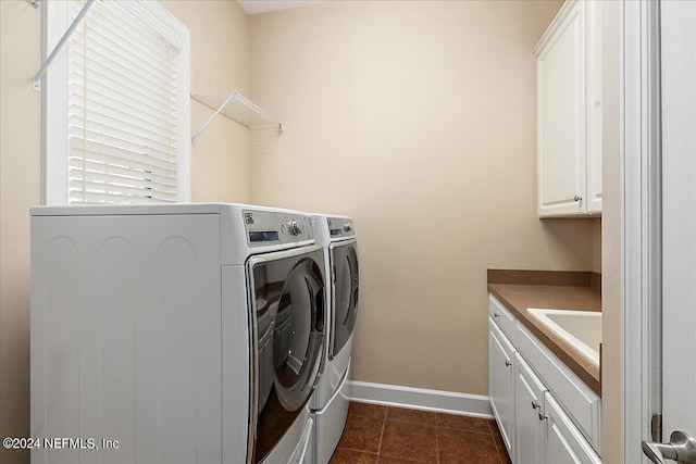 laundry area featuring cabinets, independent washer and dryer, dark tile patterned floors, and sink