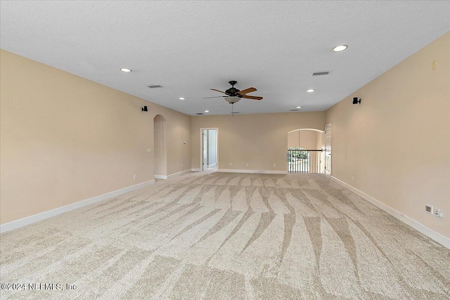 carpeted spare room featuring a textured ceiling and ceiling fan