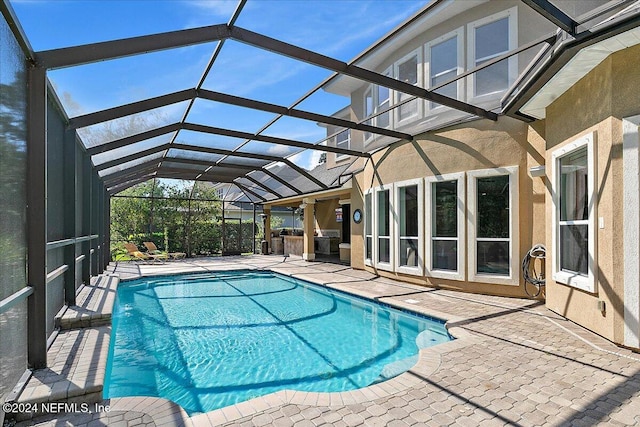 view of swimming pool with a patio and glass enclosure