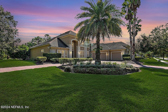 view of front of house featuring a yard and a garage