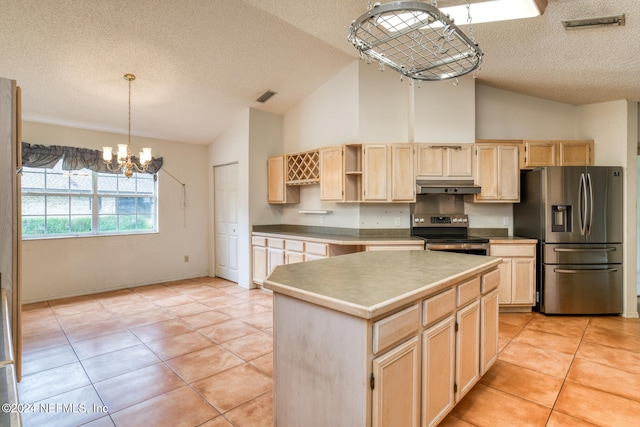 kitchen featuring a center island, stainless steel appliances, hanging light fixtures, lofted ceiling, and light tile patterned floors