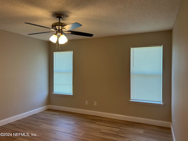 unfurnished room with a textured ceiling, light hardwood / wood-style flooring, and ceiling fan