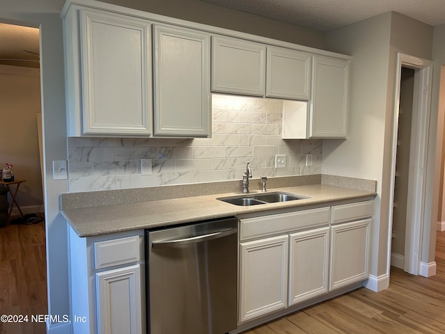 kitchen featuring white cabinetry, sink, light wood-type flooring, and stainless steel dishwasher