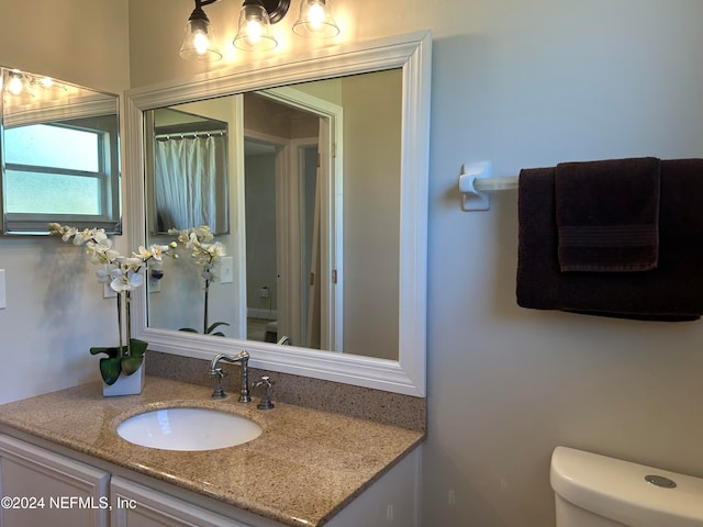 bathroom featuring vanity and toilet