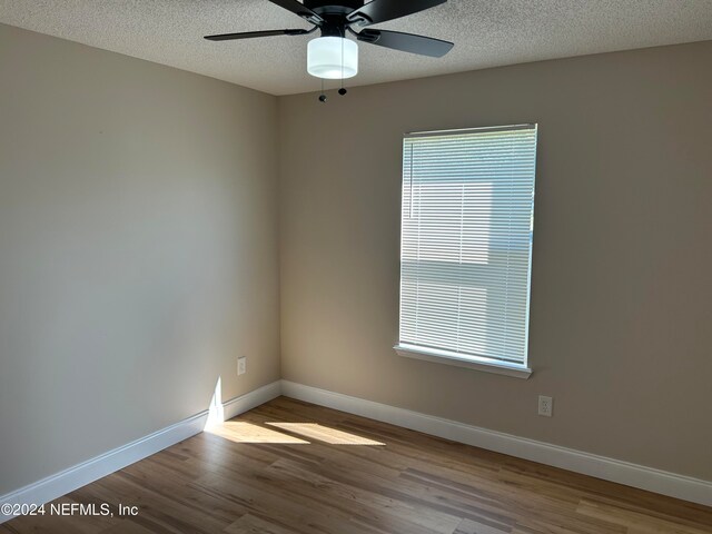 unfurnished room featuring ceiling fan, light hardwood / wood-style flooring, and a textured ceiling