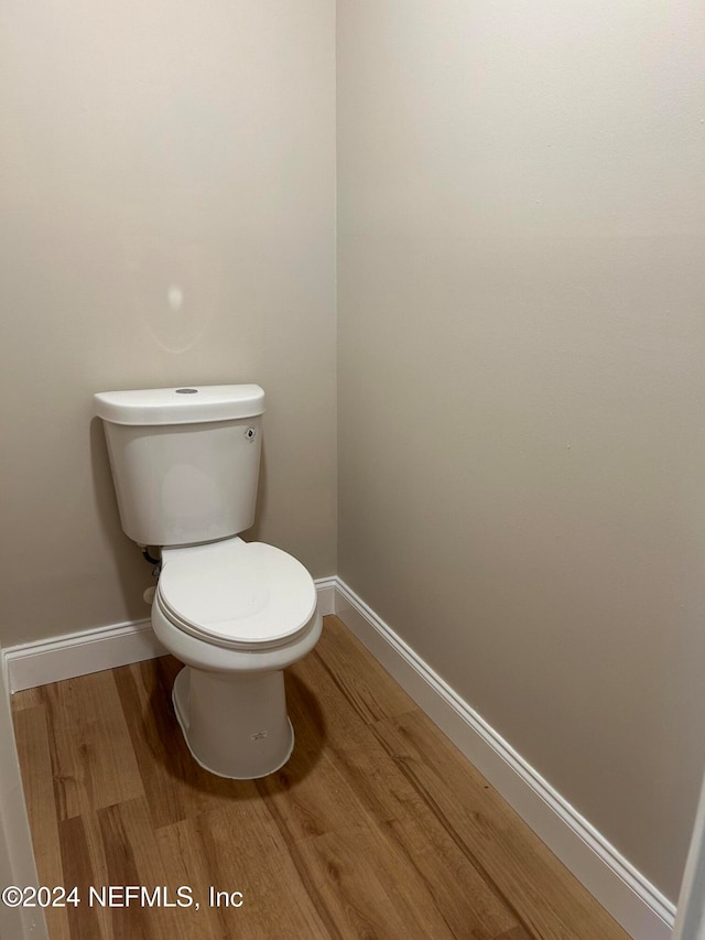 bathroom with toilet and hardwood / wood-style flooring