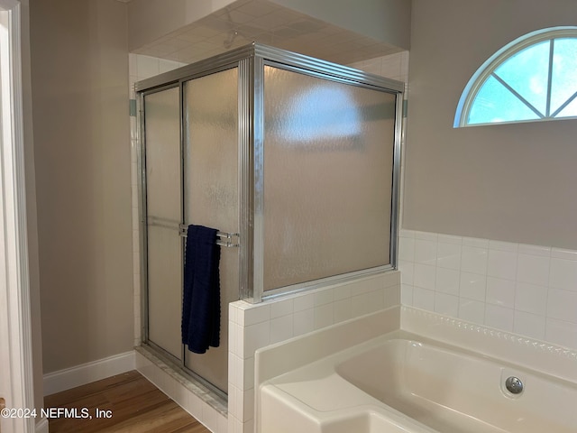 bathroom featuring independent shower and bath and wood-type flooring