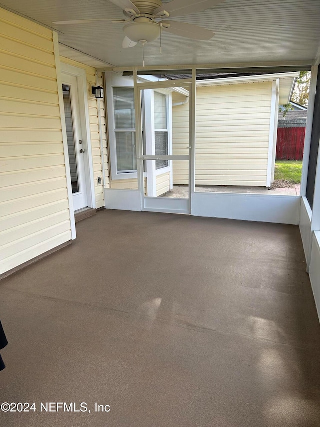 unfurnished sunroom featuring ceiling fan