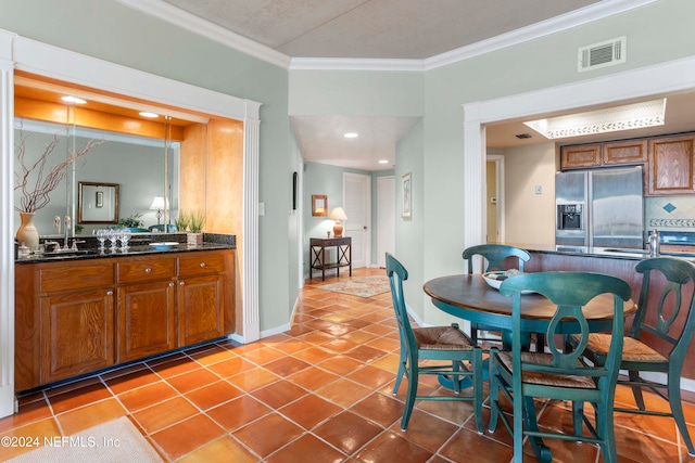 kitchen with ornamental molding, sink, stainless steel refrigerator with ice dispenser, and light tile patterned floors