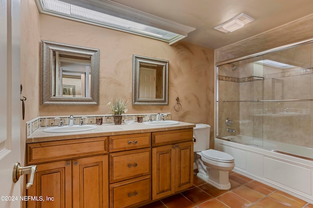 full bathroom featuring vanity, toilet, combined bath / shower with glass door, and tile patterned flooring