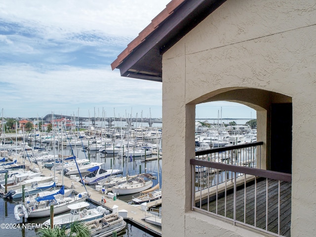 dock area with a water view and a balcony