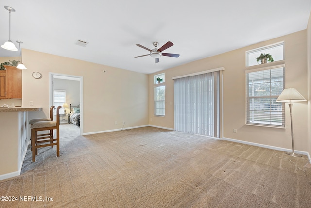 carpeted living room with ceiling fan and a wealth of natural light