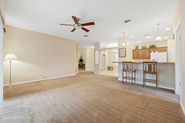 unfurnished living room with light colored carpet and ceiling fan