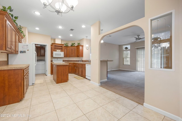 kitchen with sink, white appliances, a kitchen island, light carpet, and ceiling fan with notable chandelier