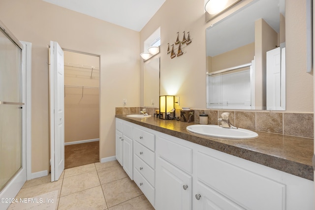 bathroom featuring walk in shower, vanity, tasteful backsplash, and tile patterned floors