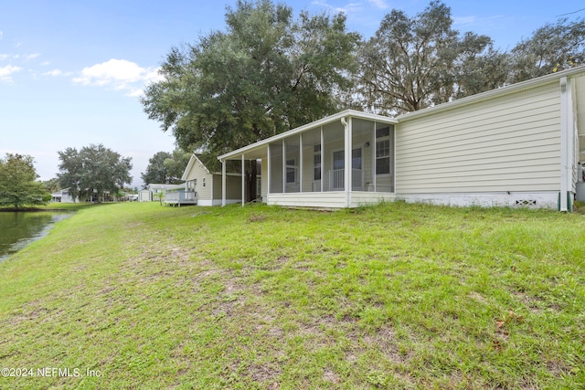 back of house featuring a yard and a sunroom