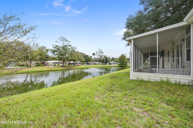 view of yard with a water view and a sunroom