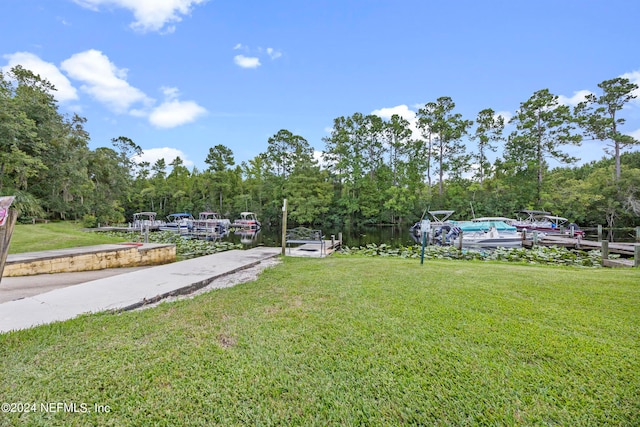 view of yard with a water view and a dock