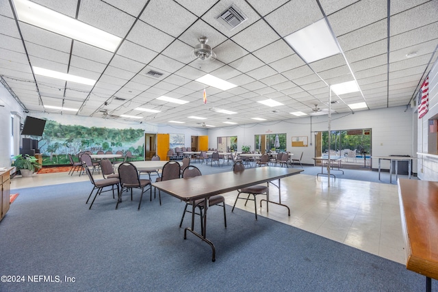 interior space featuring ceiling fan and a drop ceiling