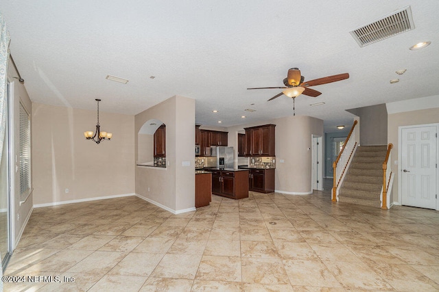 kitchen with stainless steel fridge, dark brown cabinetry, a textured ceiling, decorative light fixtures, and ceiling fan with notable chandelier