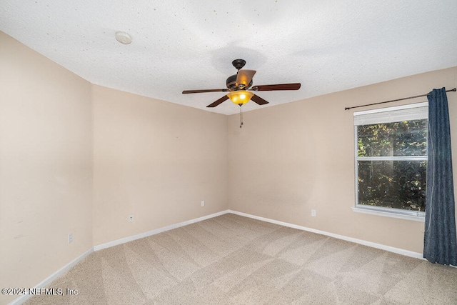 carpeted spare room with a textured ceiling and ceiling fan