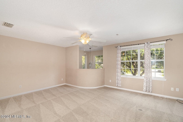 carpeted empty room featuring a textured ceiling and ceiling fan