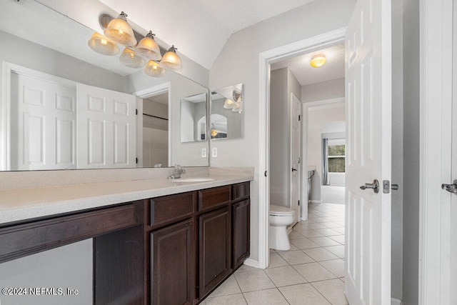 bathroom with vaulted ceiling, toilet, vanity, tile patterned floors, and a textured ceiling