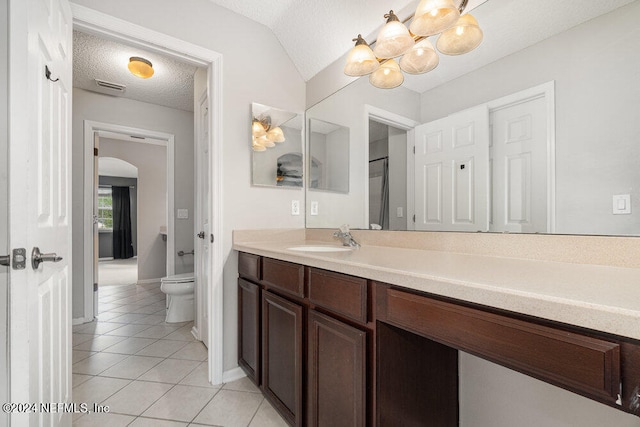 bathroom featuring toilet, tile patterned floors, vanity, and a textured ceiling