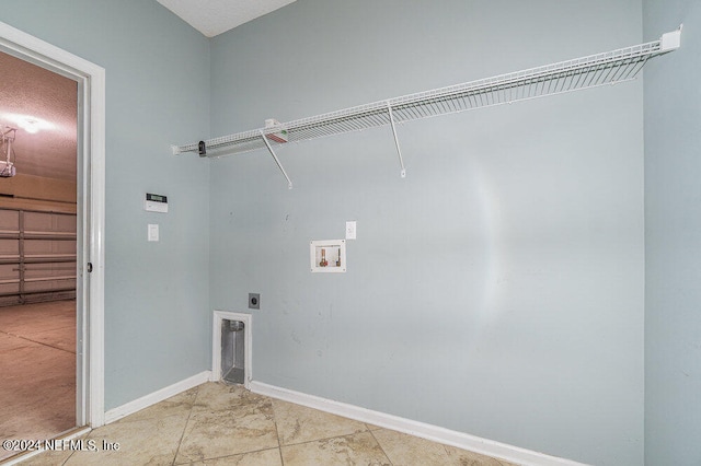 washroom featuring light tile patterned floors, hookup for a washing machine, a textured ceiling, and hookup for an electric dryer